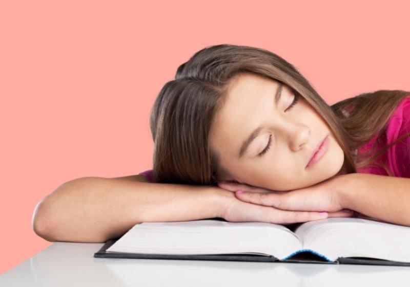 teenager falling asleep on books